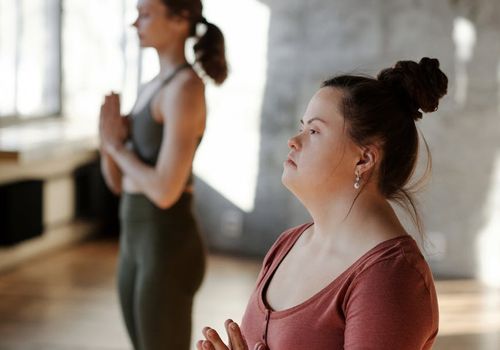Woman practicing morning yoga in a bright, sunlit room, feeling energized.
